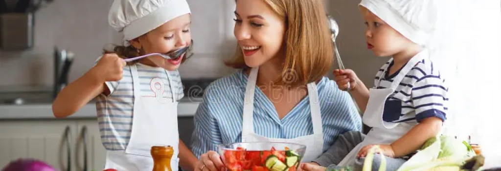 comer-saudável-mãe-e-as-crianças-felizes-da-família-preparam-salada-vegetal-99663061